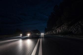 Автомобиль выезжает на встречную полосу для обгона ночью на трассе.
